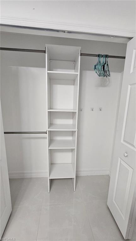 White closet system with five open shelves and two chrome hanging rods