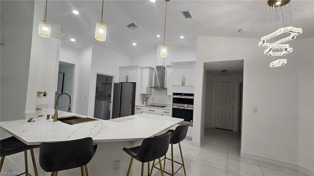 Contemporary kitchen island featuring a waterfall-edge countertop and integrated sink