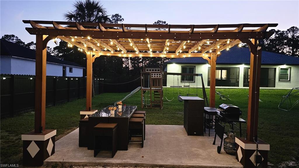 Expansive outdoor patio with a pergola featuring integrated string lighting