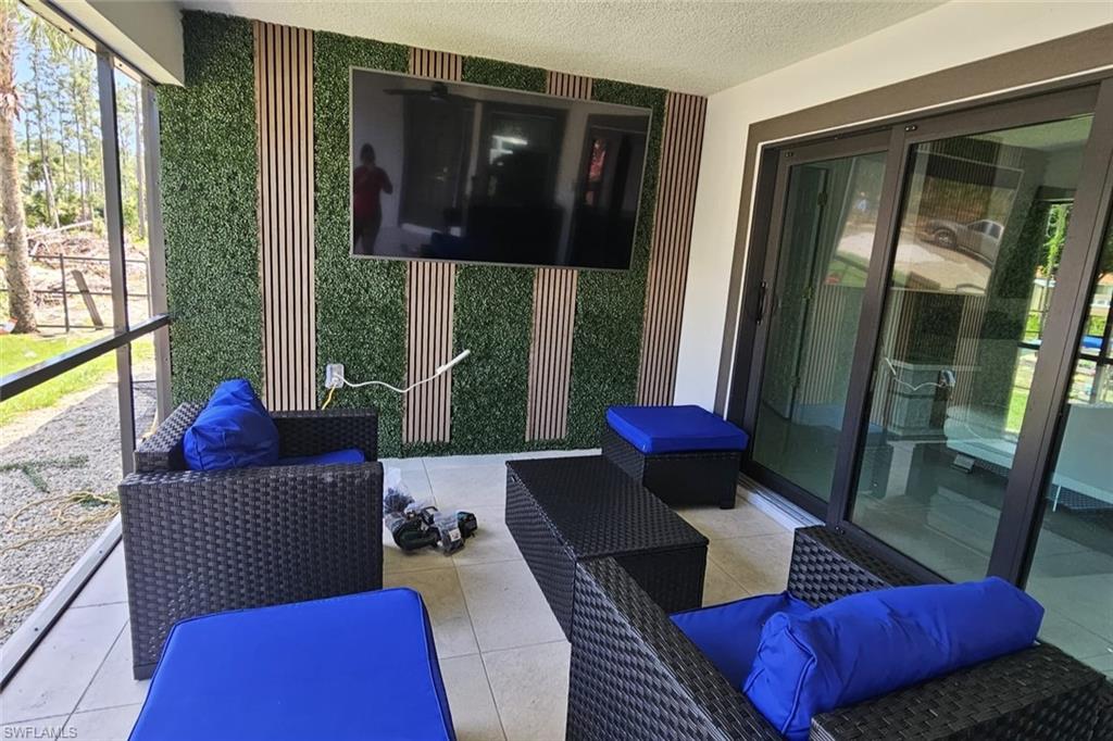 Screened outdoor patio featuring a unique vertical garden wall with integrated wood-finish slats