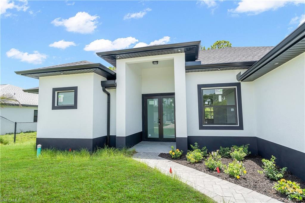 Contemporary exterior featuring white stucco walls with a dark base trim
