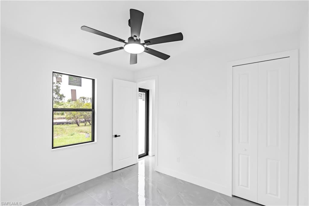 Spacious room featuring a contemporary ceiling fan with integrated lighting, a rectangular window with black trim, and bi-fold closet doors