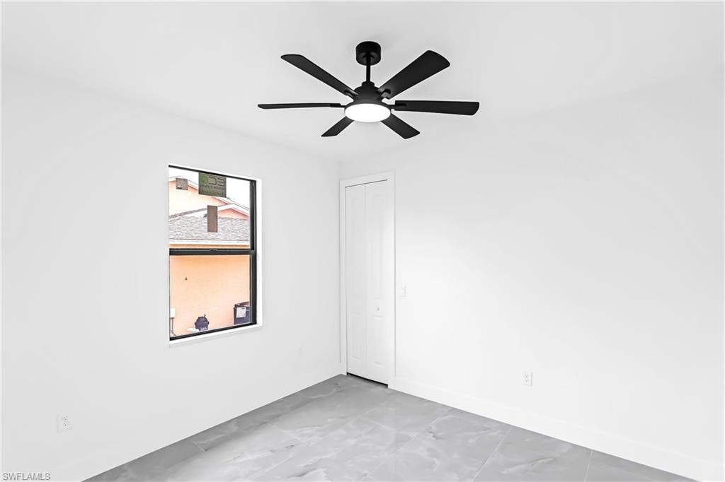 Room featuring a modern black ceiling fan with integrated lighting, a single window, and a white bi-fold closet door