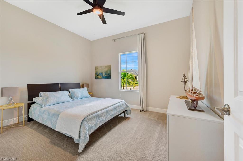 Carpeted bedroom featuring ceiling fan