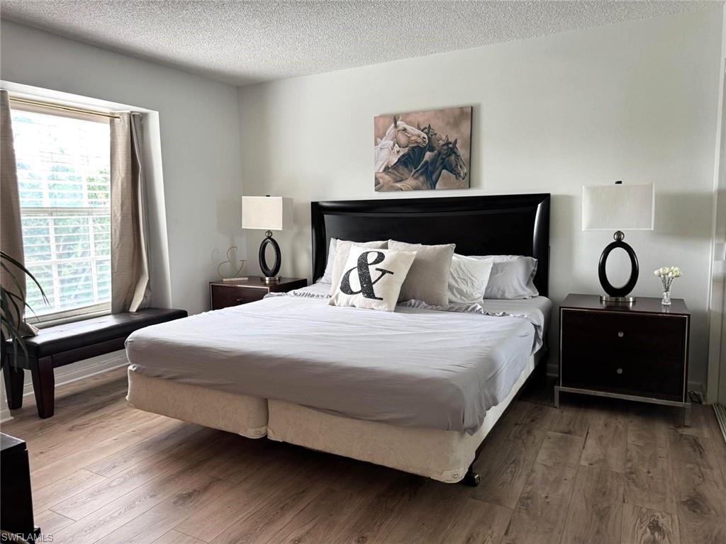 Bedroom featuring wood finished floors and a textured ceiling