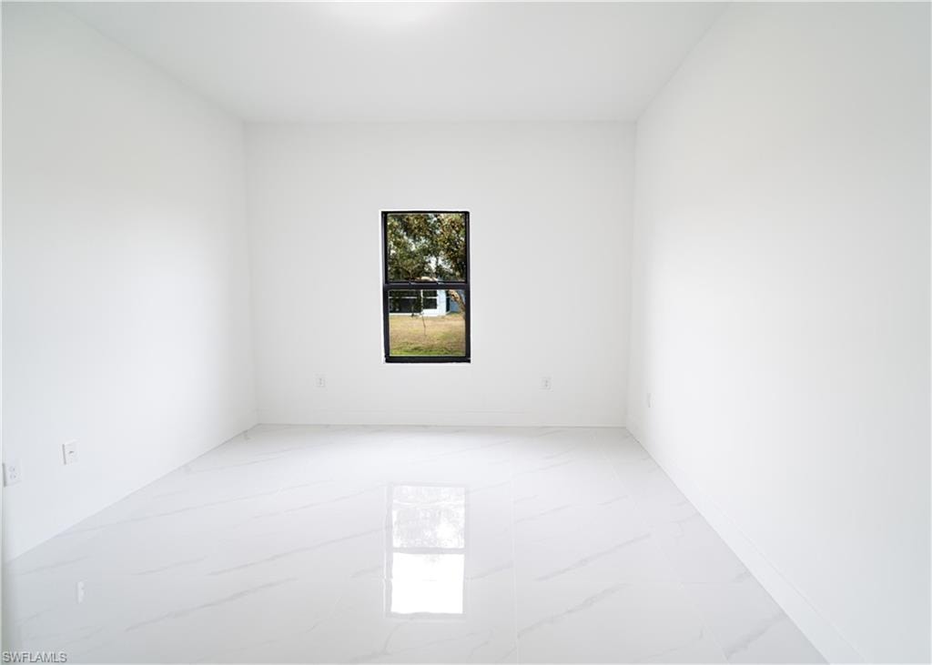 Spacious interior featuring white walls and white tile flooring