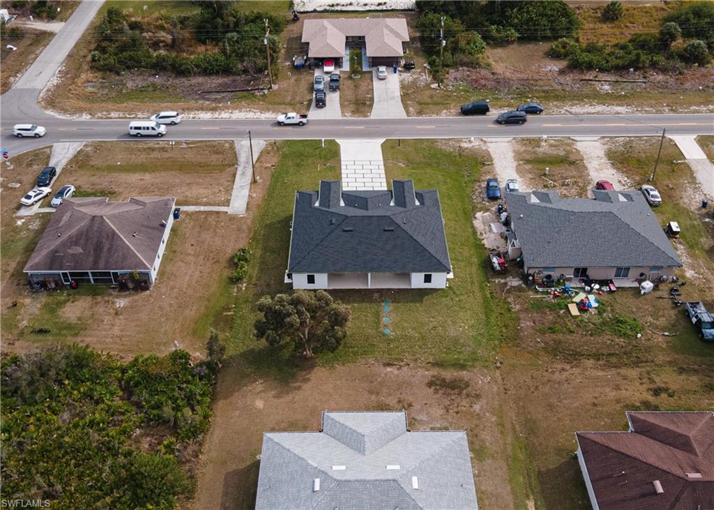 Newly constructed property featuring a dark shingle roof and a light-toned exterior