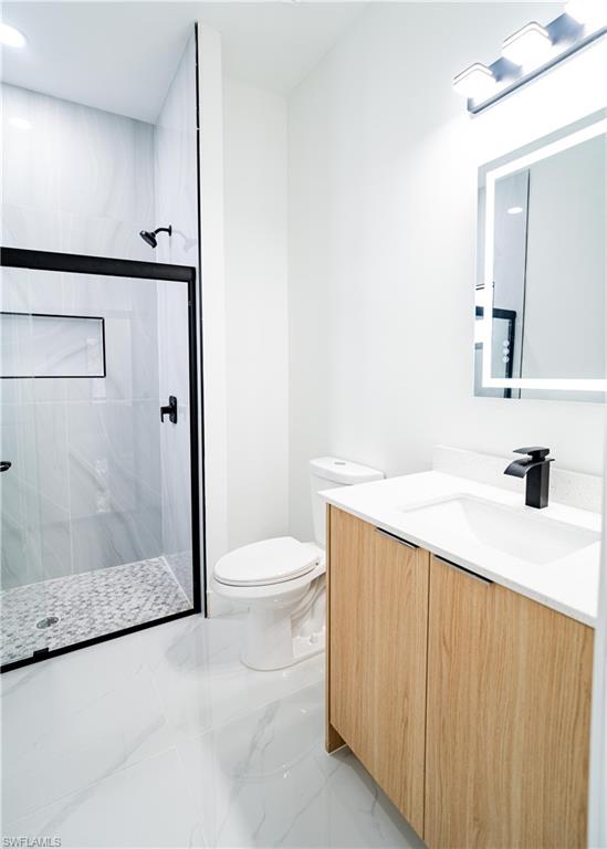 Modern bathroom featuring a glass-enclosed shower with black fixtures and a built-in niche