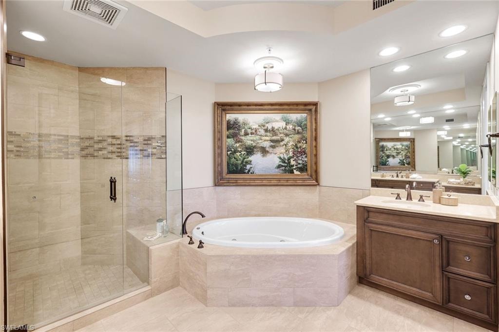Frameless glass shower with soaking tub and dual vanities.