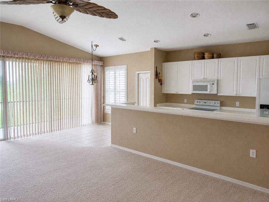 Open-concept living space featuring a vaulted ceiling and a ceiling fan