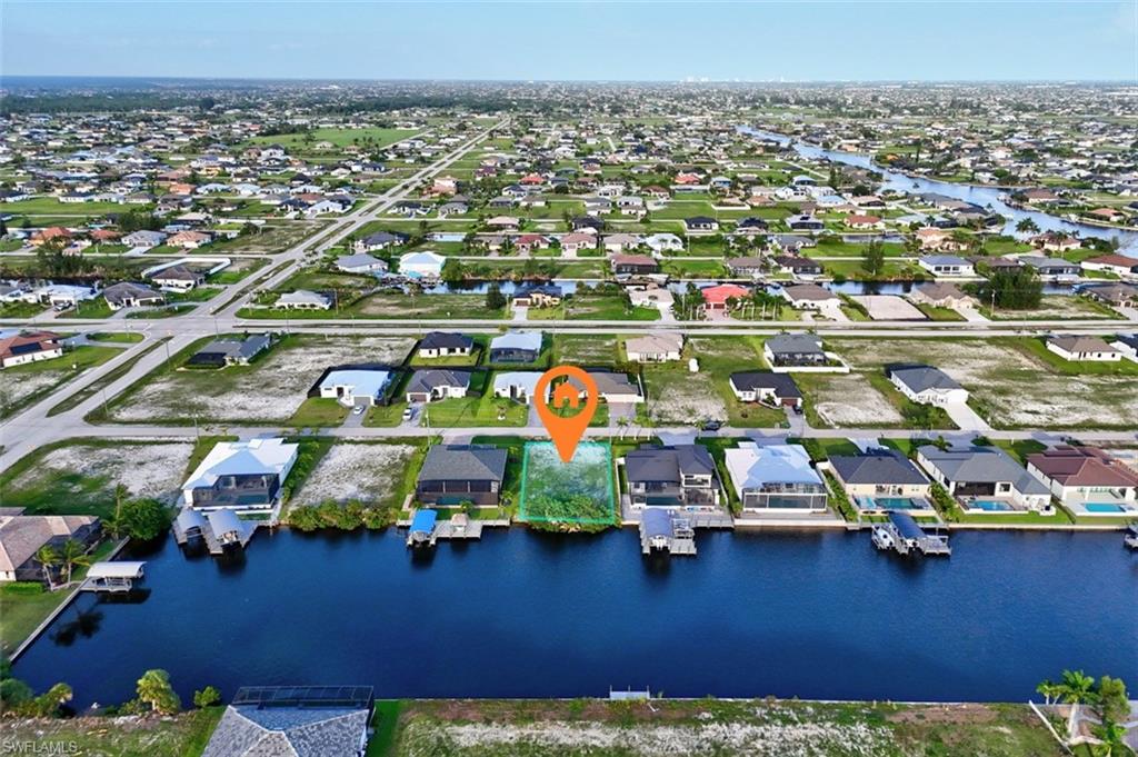 Canal-front lot in a developed residential area with multiple adjacent homes featuring private boat docks