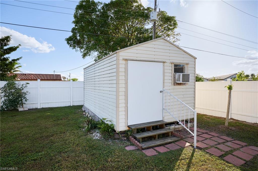 Detached storage shed featuring horizontal siding, a gabled roof, and a single entry door