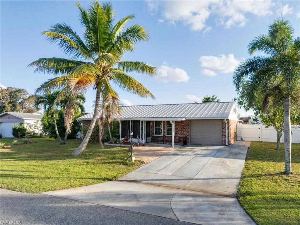 Brick-front home featuring a metal roof and an attached garage