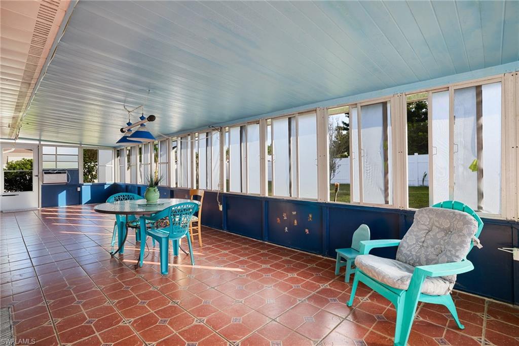 Enclosed patio with terracotta-style tile flooring and a light blue paneled ceiling