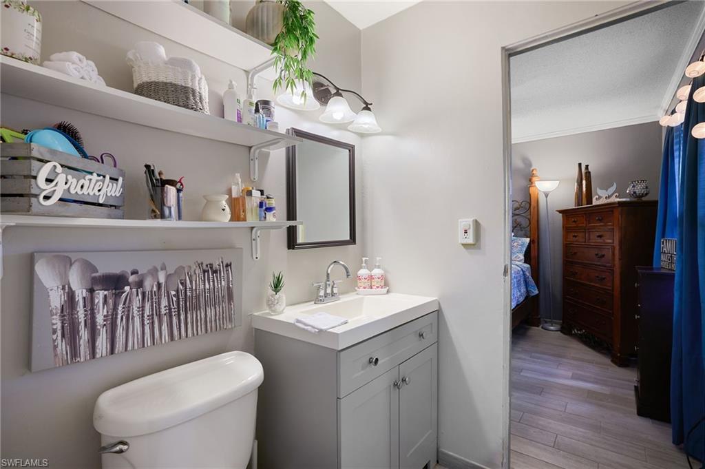 Bathroom featuring a single vanity with light grey cabinetry, a square undermount sink, and a framed mirror