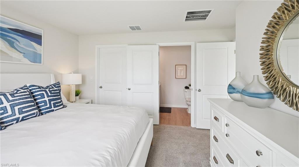 Model Home. The bedroom features light-colored walls and carpeted flooring