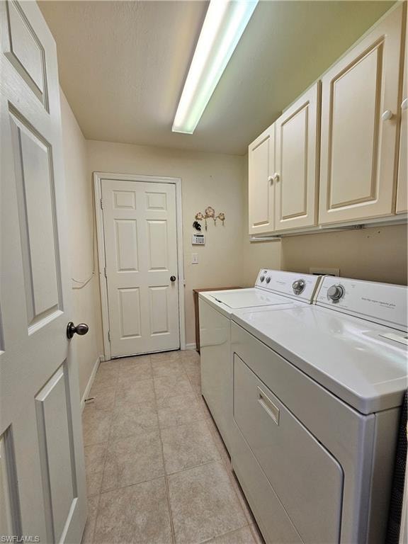 Functional utility area featuring overhead cabinetry, a fluorescent light fixture, and neutral tile flooring