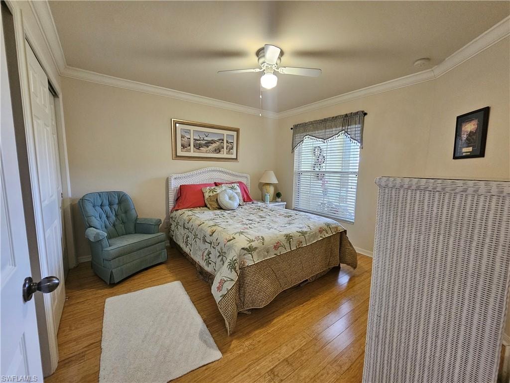 Room with wood-finish flooring, crown molding, and a ceiling fan with integrated lighting