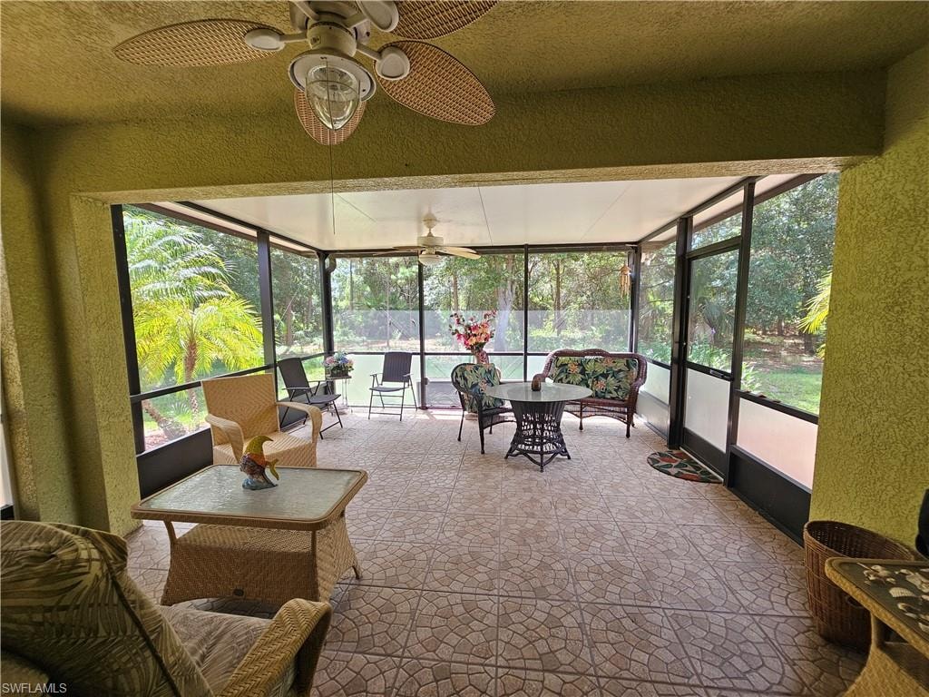 Screened outdoor living area featuring textured plaster walls and a textured tile floor