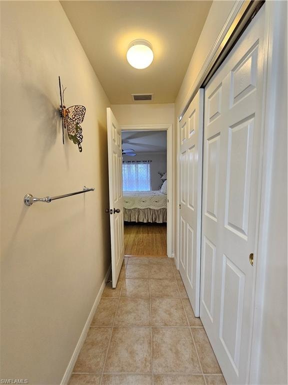 Hallway featuring ceramic tile flooring, recessed ceiling light, and white paneled bi-fold doors