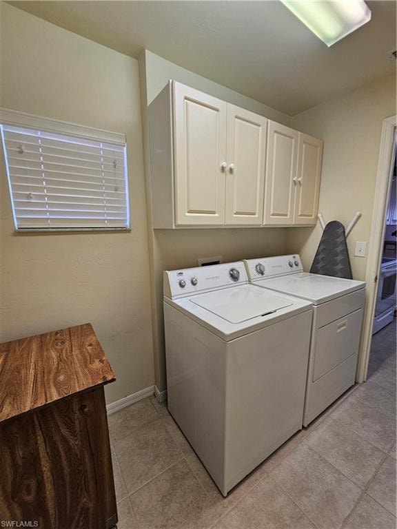 Dedicated laundry area featuring overhead cabinetry, a window with blinds, and tiled flooring