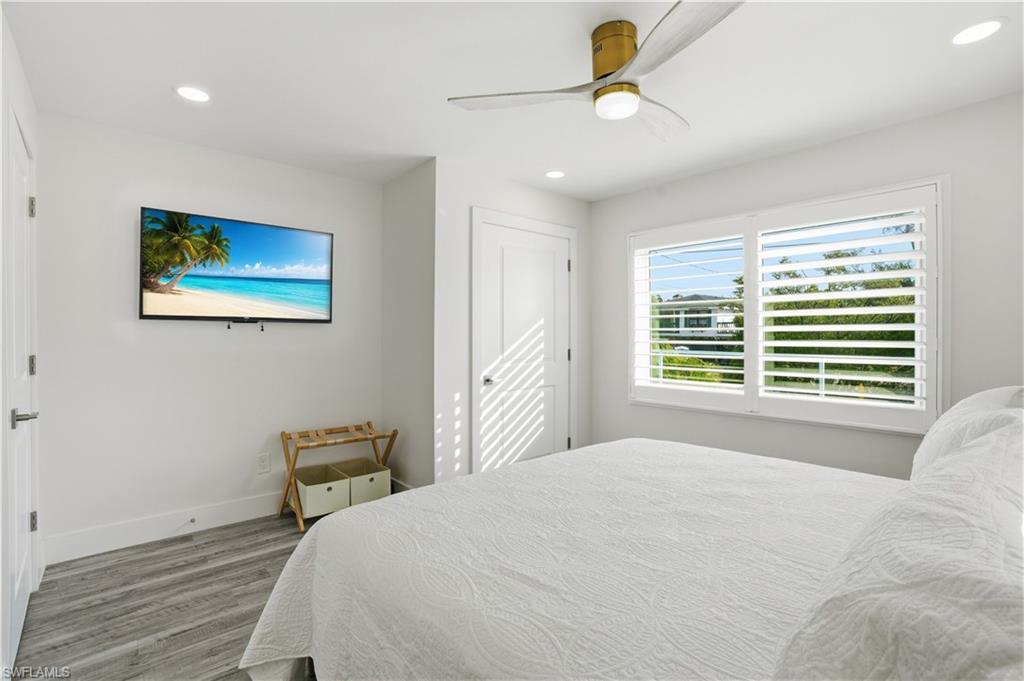 Bedroom with wood finished floors, recessed lighting, and ceiling fan - Virtually Edited Image