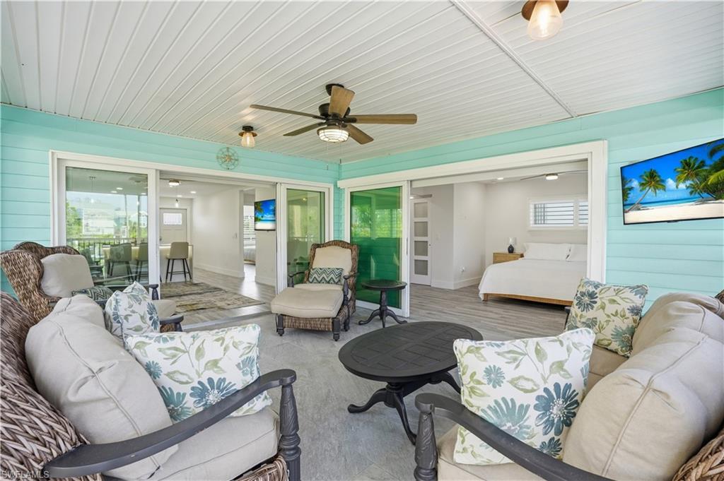 Sunroom featuring outdoor lounge area, ceiling fan, and healthy amount of natural light - Virtually Edited Image