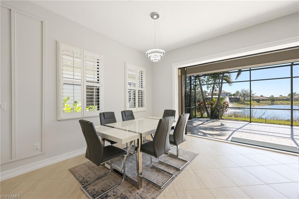 Light-filled interior featuring expansive glass sliding doors opening to a screened patio overlooking a water feature