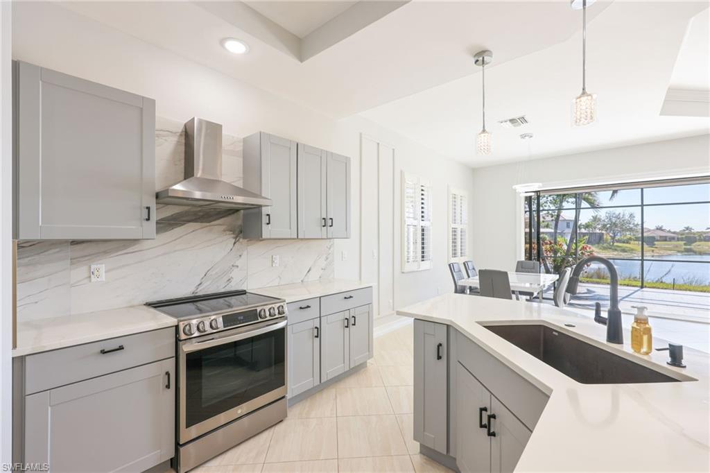Contemporary kitchen featuring gray cabinetry, stainless steel appliances, and white countertops