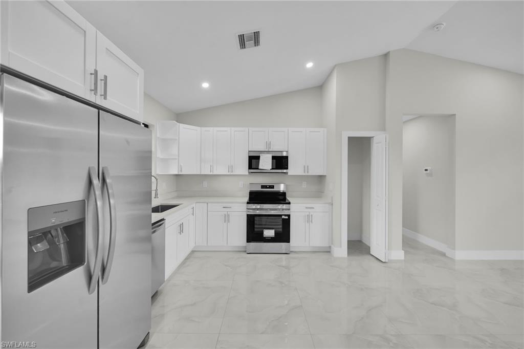 Modern kitchen featuring white shaker cabinetry and stainless steel appliances