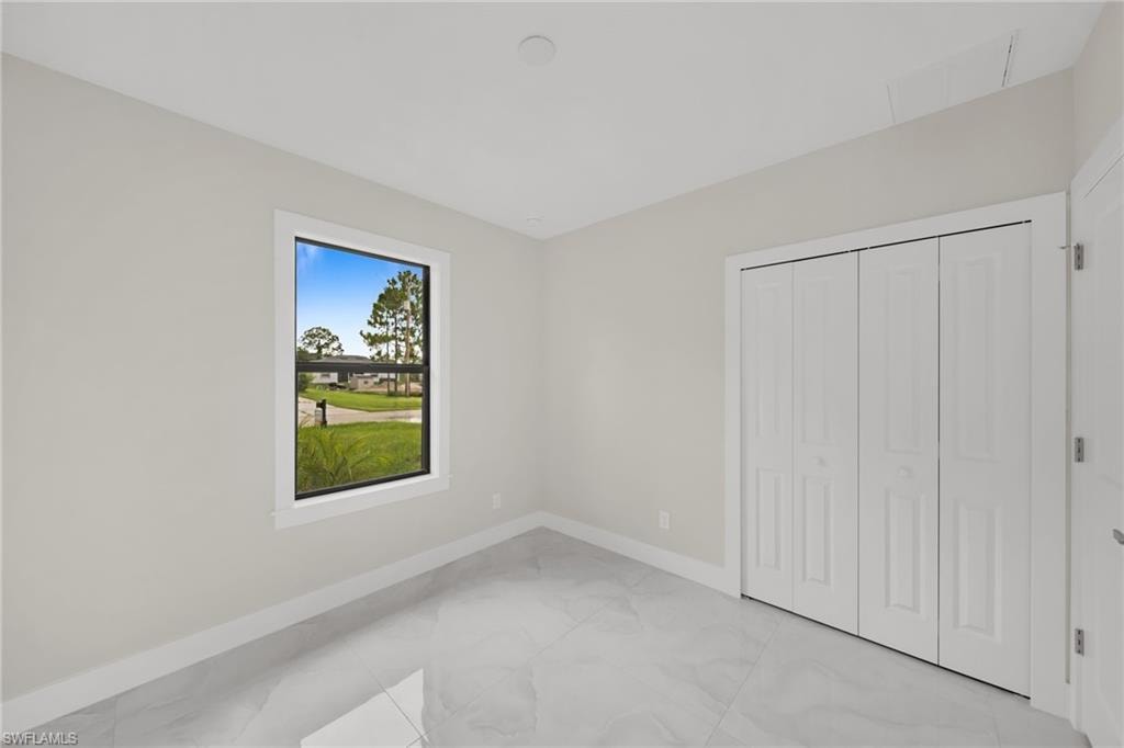 Interior room featuring light gray walls, white trim, and polished tile flooring