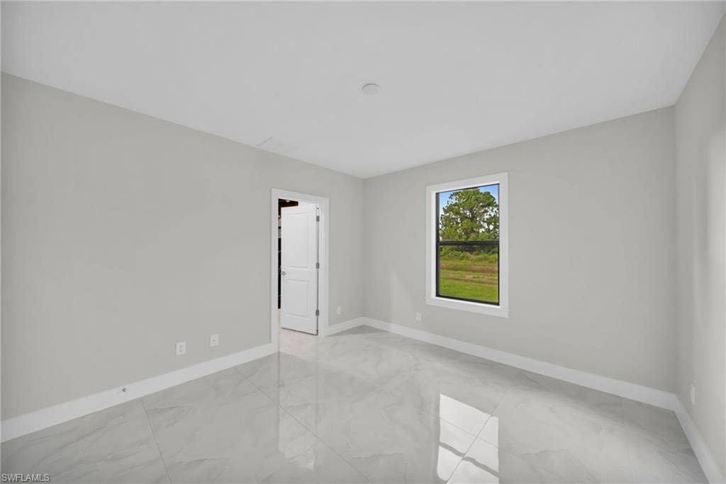 Interior room featuring light gray walls, white trim, and polished tile flooring