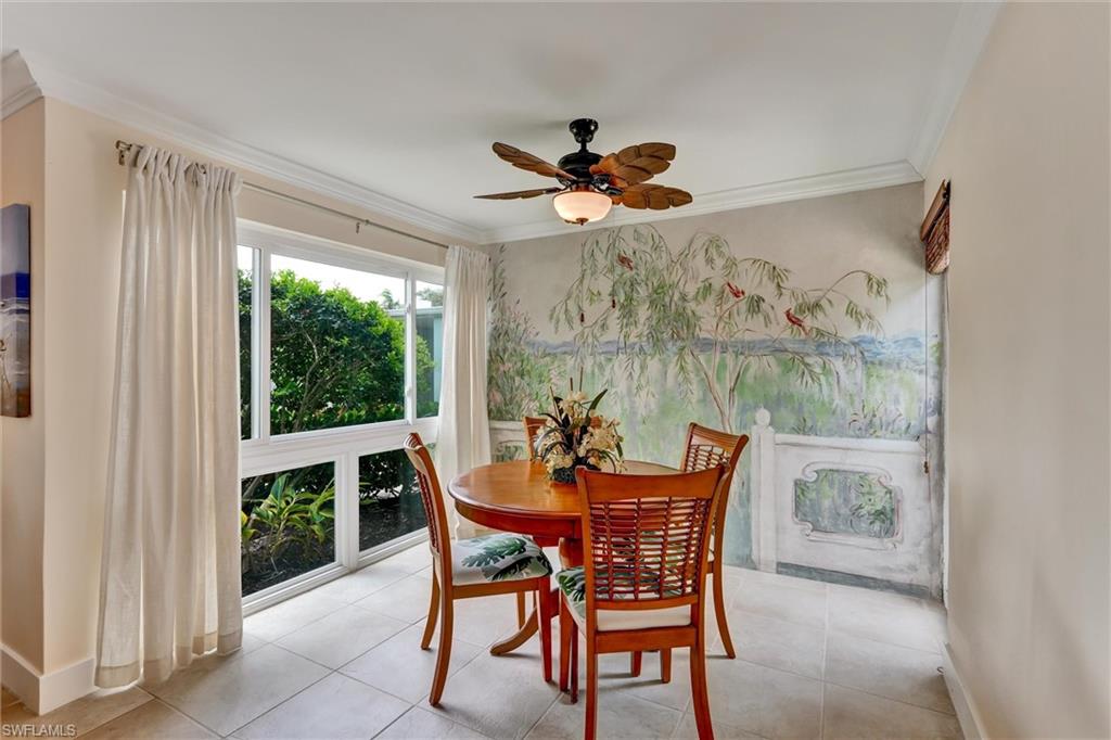 Dining area with large floor to ceiling window on one side and another window on the courtyard side.Mural painted by a local artist about 40 years ago.