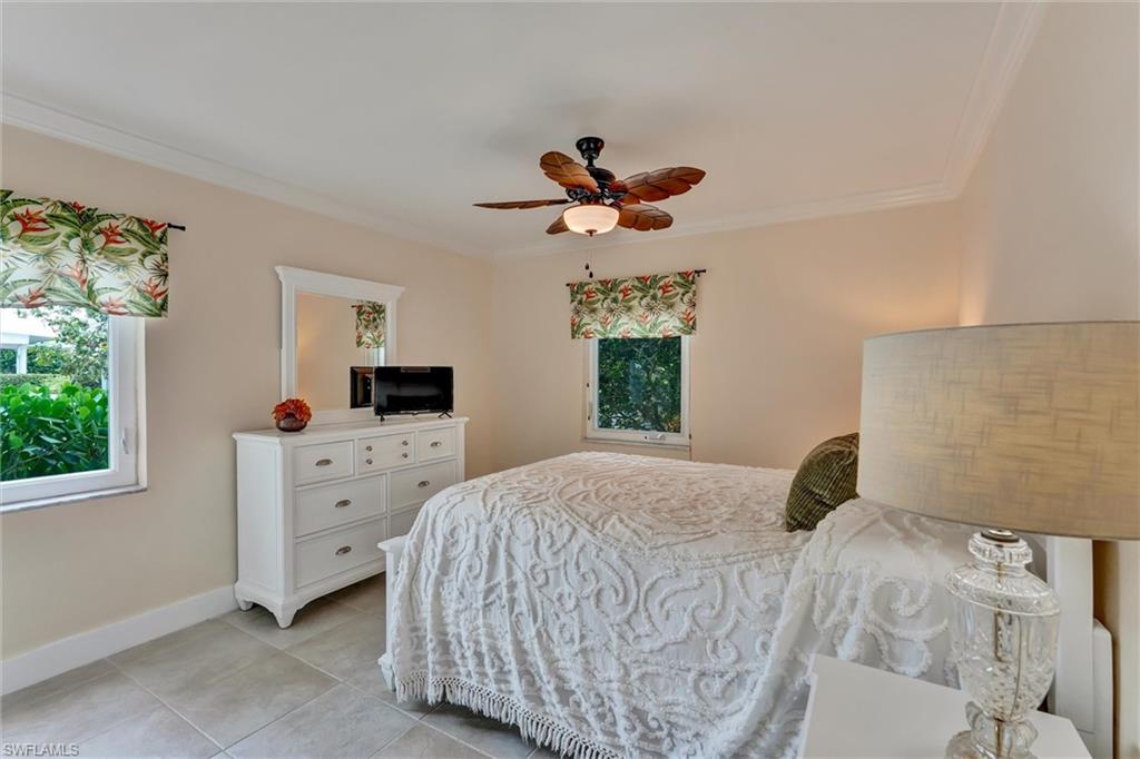 Bedroom number 1 with 2 storm impact windows, tile floor and ceiling fan