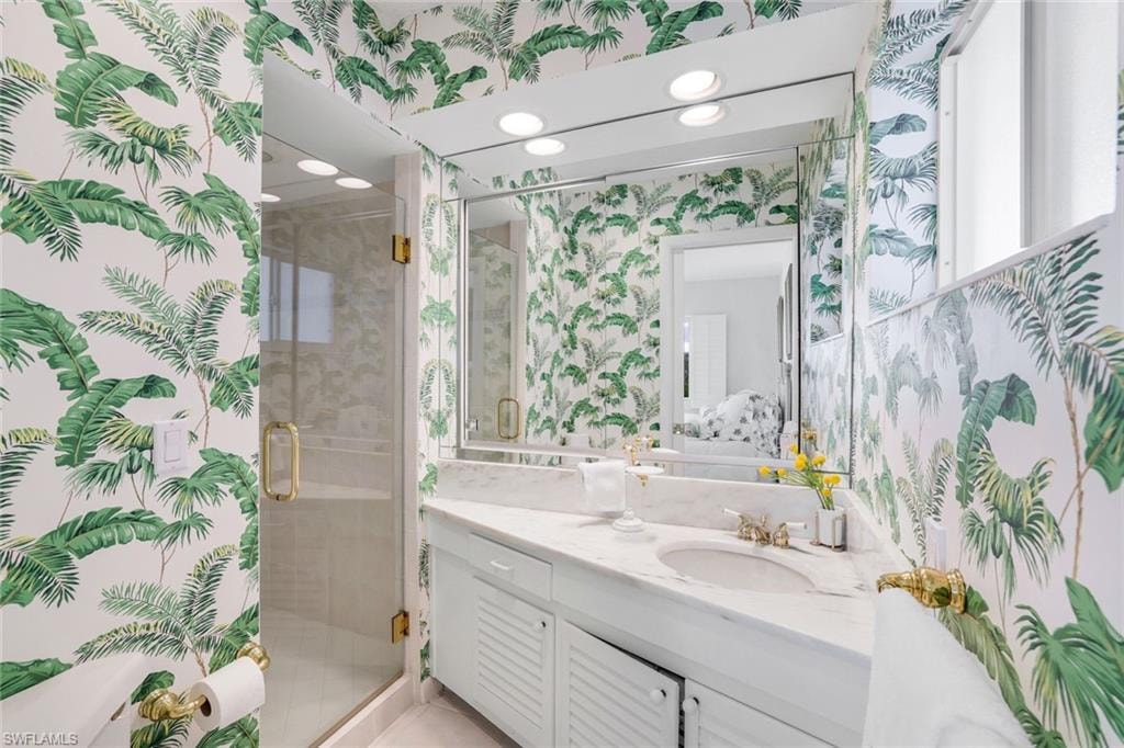 Bathroom with wallpapered walls, vanity, a shower stall, connected bathroom, and recessed lighting