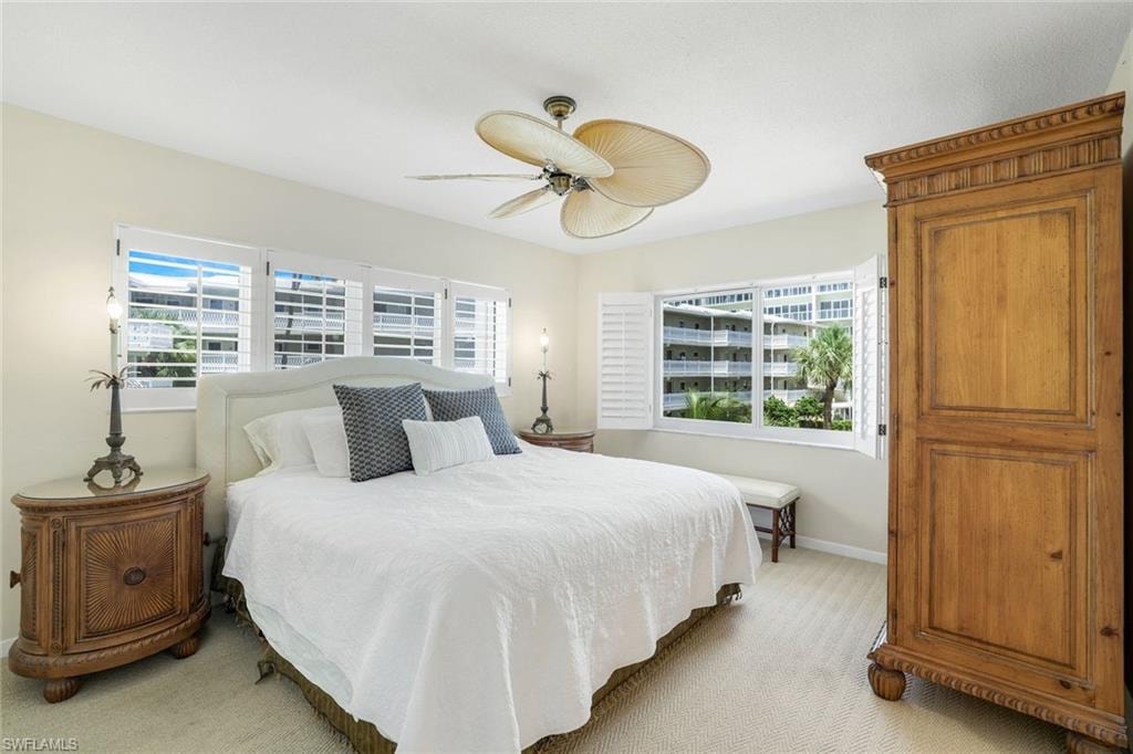 Carpeted bedroom with baseboards and a ceiling fan