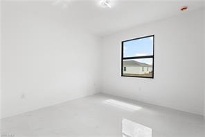 Bright interior space featuring a single window with black framing, white walls, and light-colored tile flooring