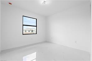 Room with white walls, white tile flooring, and a single black-framed window