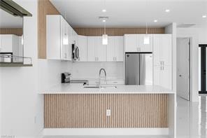 Modern kitchen featuring a waterfall island with wood-finish slat detailing