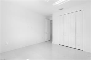 Bright interior space featuring white walls and large format tile flooring
