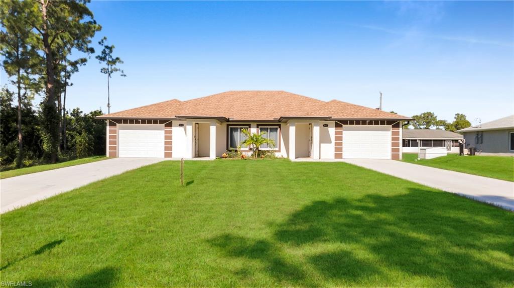 Duplex property featuring a brown shingle roof, two distinct white garage doors with vertical brown accent panels, two separate front entrances with covered porticos, and two concrete driveways