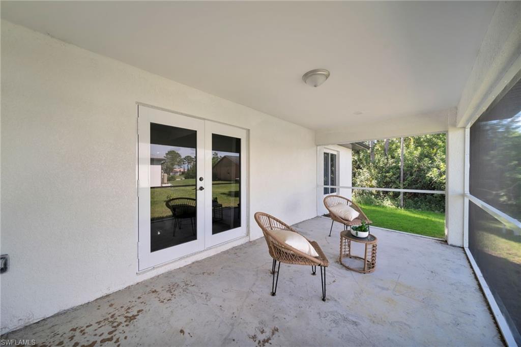 Covered outdoor patio featuring a concrete surface and white stucco walls