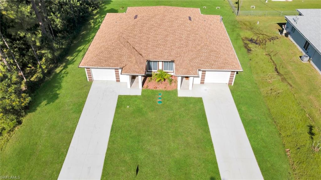 Duplex property featuring two distinct units, each with a private driveway and garage