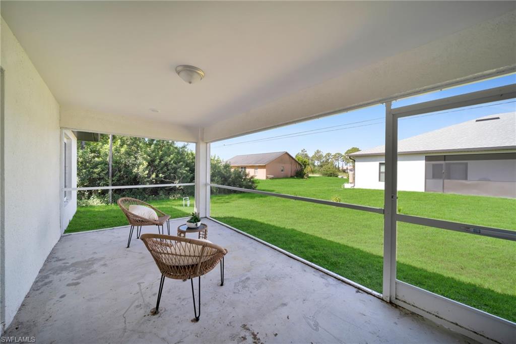 Screened concrete patio featuring an overhead light fixture