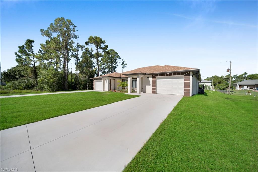 Contemporary single-story residence featuring a two-car garage, secondary single-car garage, and a concrete driveway