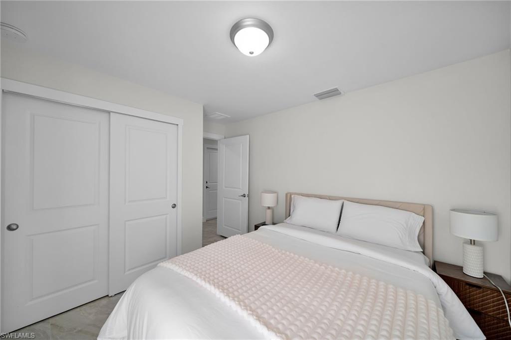Bright interior space with white walls, ceiling-mounted light fixture, and tile flooring