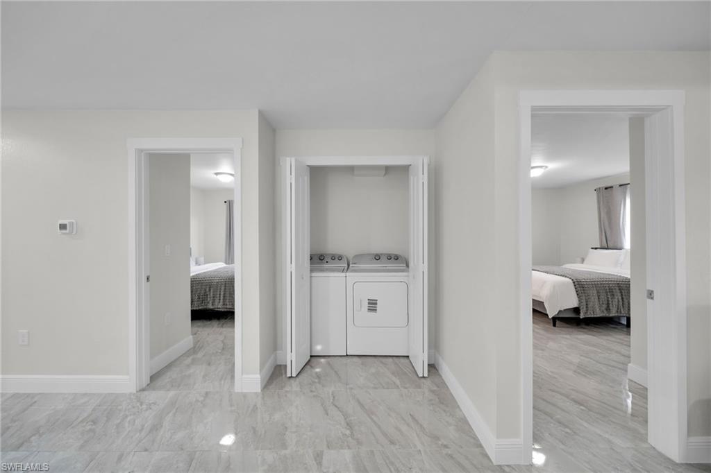 Central laundry closet with bi-fold doors and included appliances, flanked by two doorways