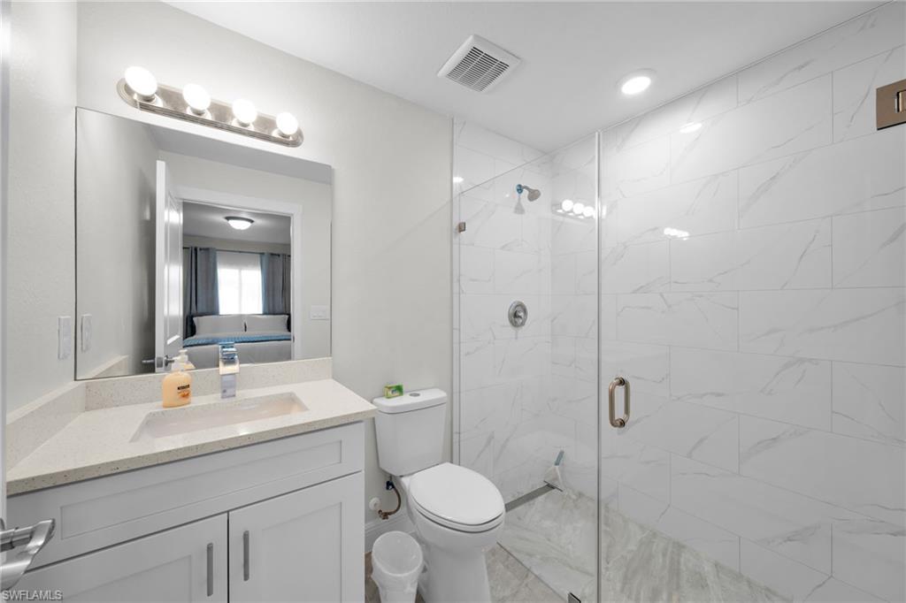 Bathroom featuring a white vanity with a light-toned countertop, an undermount sink, and a chrome faucet