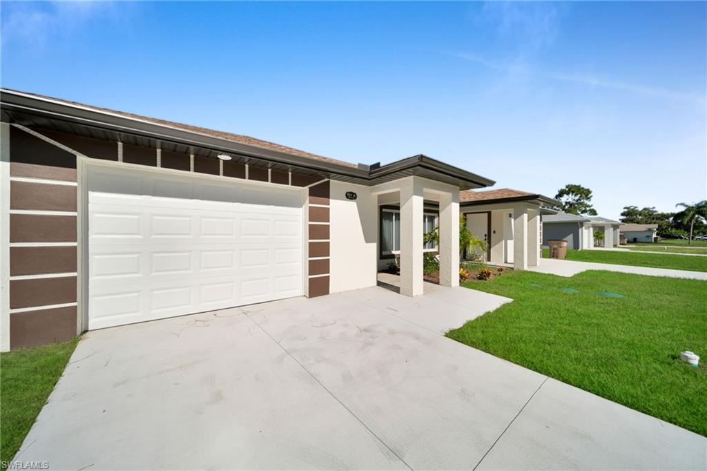 Contemporary exterior with a white panel garage door, concrete driveway, and contrasting brown and white facade