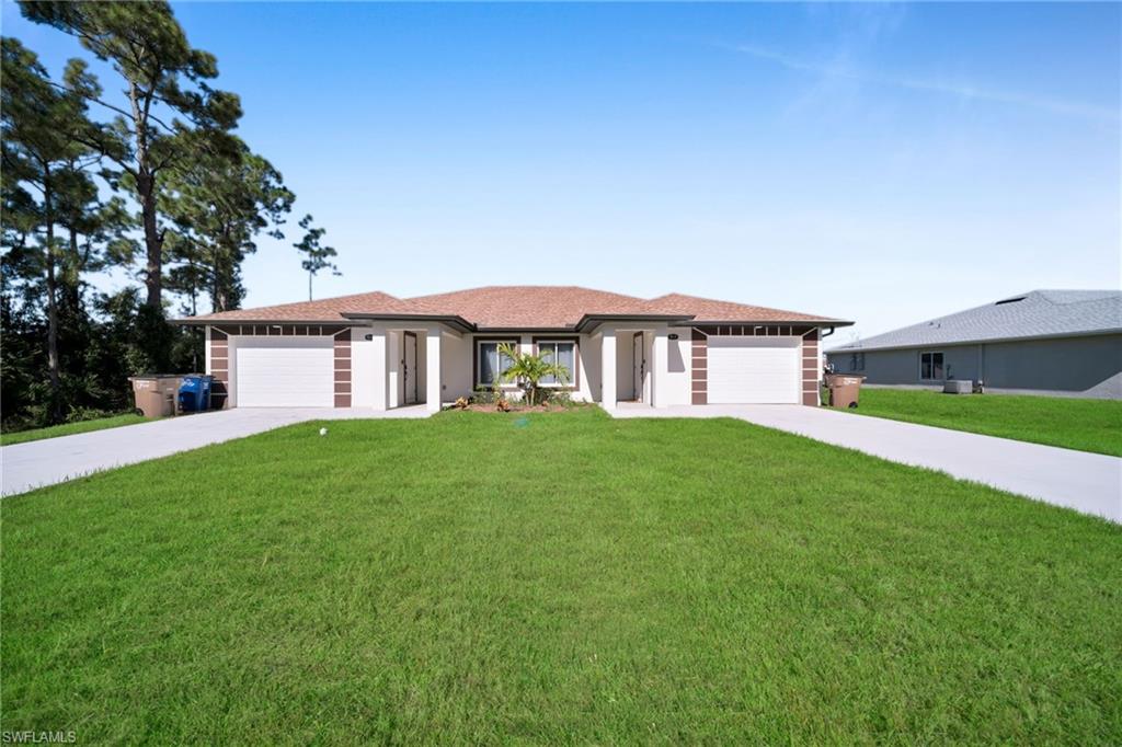Duplex property featuring a neutral stucco exterior with contrasting brown accents, individual single-car garages, and separate paved driveways